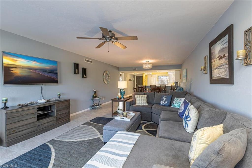 Living area with a ceiling fan and baseboards