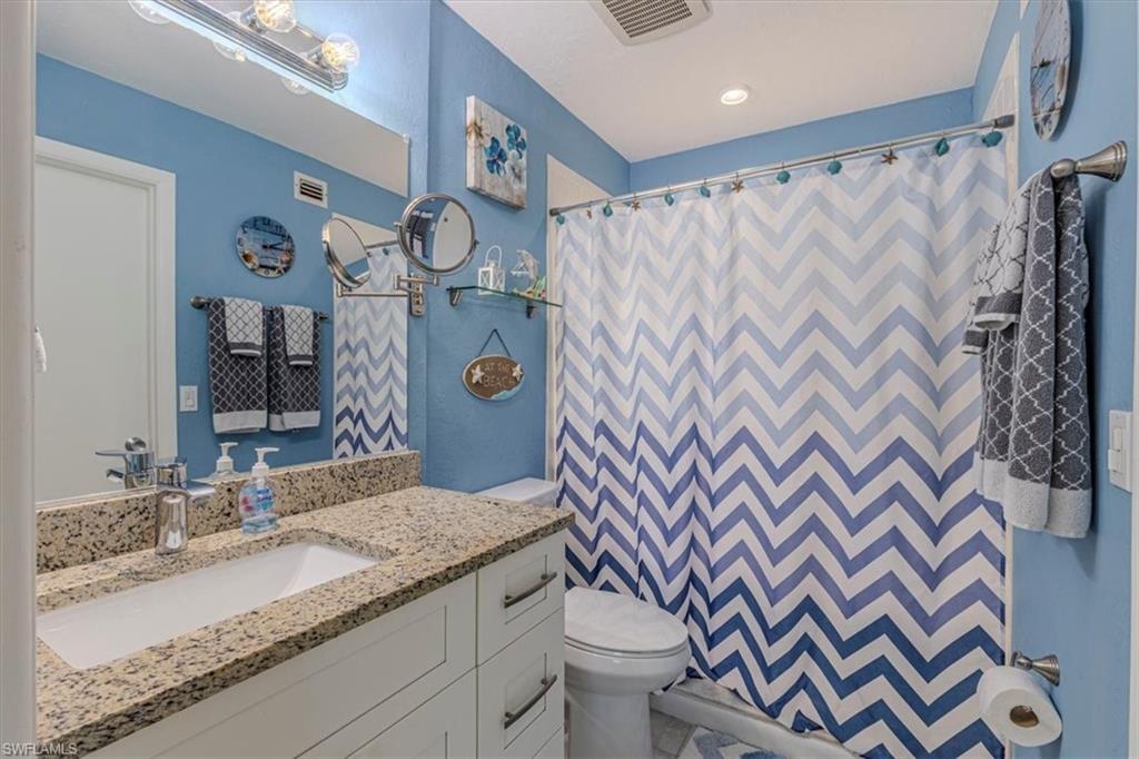 Full bath featuring curtained shower and vanity