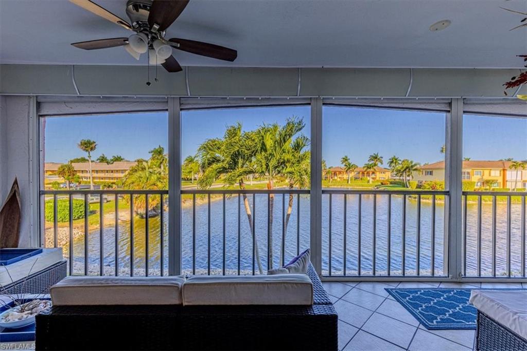 Sunroom with a water view, tile patterned floors, and a residential view