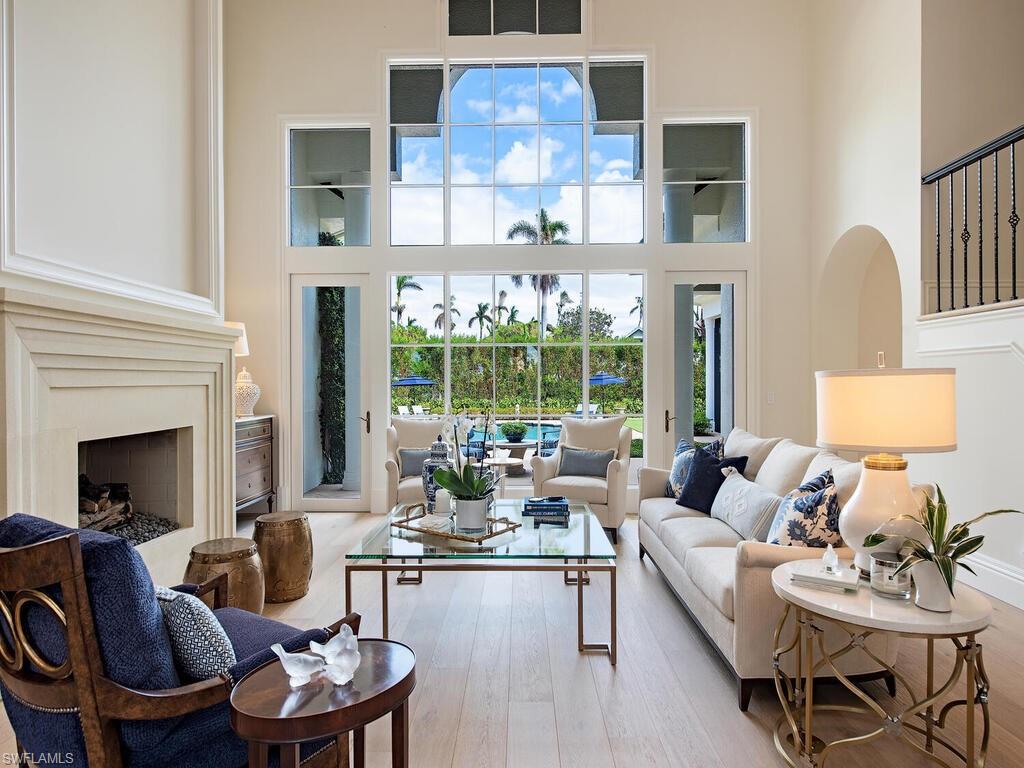 Living area featuring a fireplace, hardwood / wood-style flooring, and a high ceiling