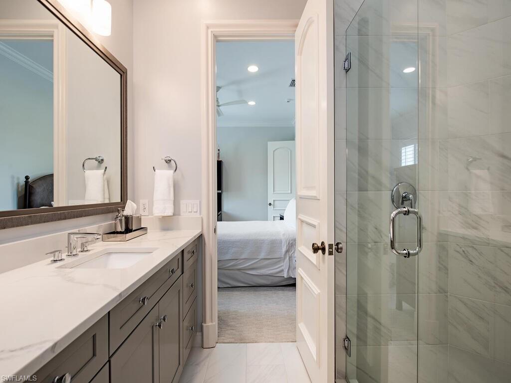 Bathroom with ensuite bath, vanity, a stall shower, ornamental molding, and light carpet