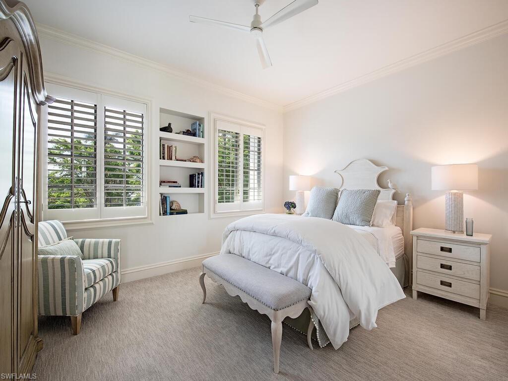 Bedroom with crown molding, light carpet, and ceiling fan
