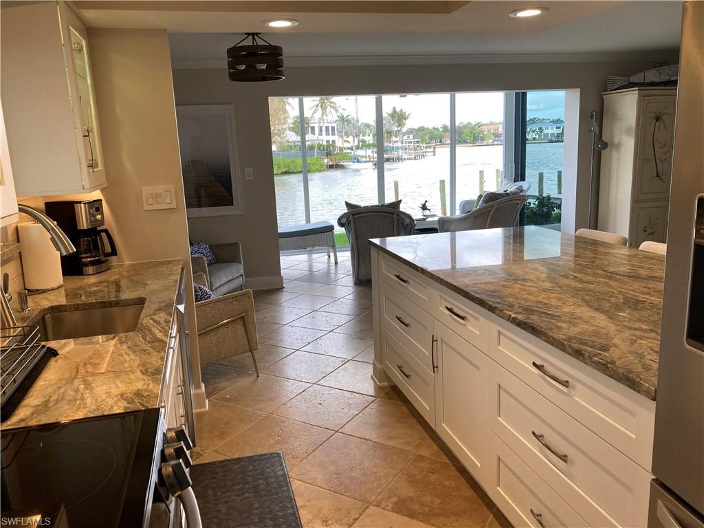 Kitchen with white cabinets, dark stone counters, electric range oven, a water view, and recessed lighting