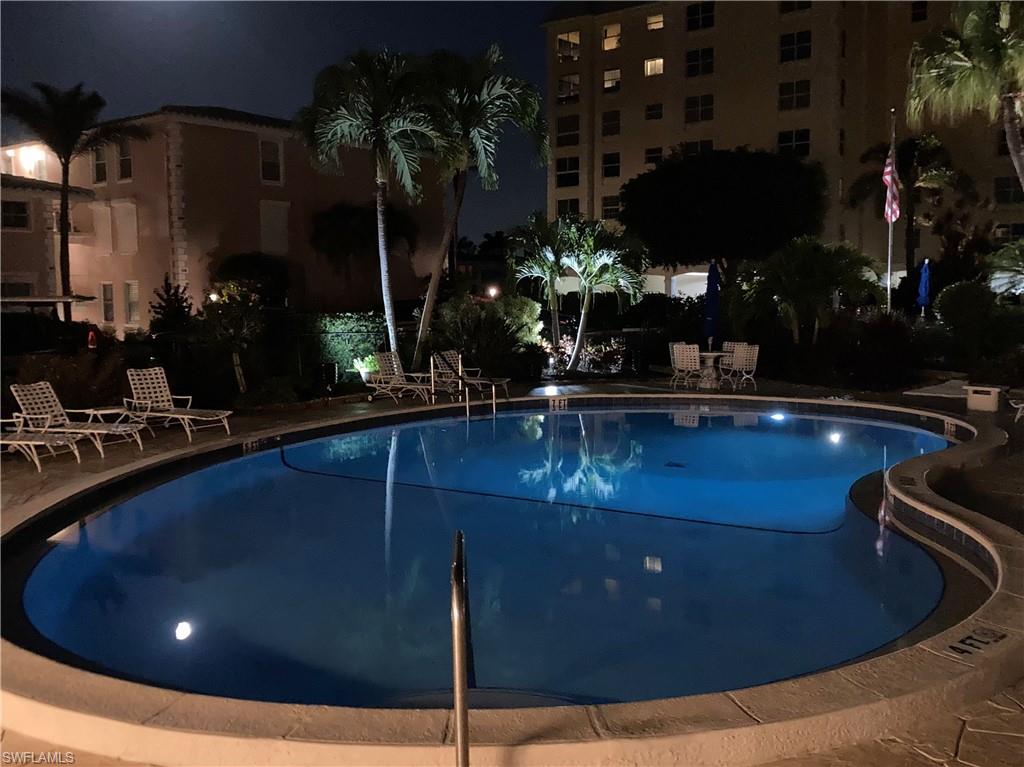 Pool at night with a patio and a community pool