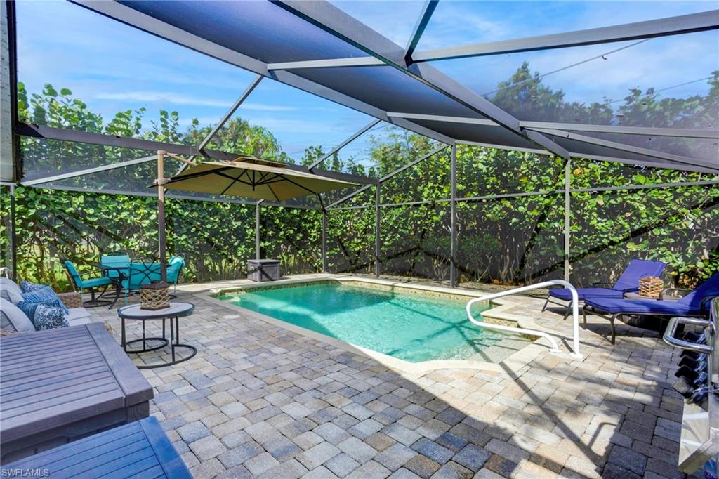 View of swimming pool featuring glass enclosure and a patio area
