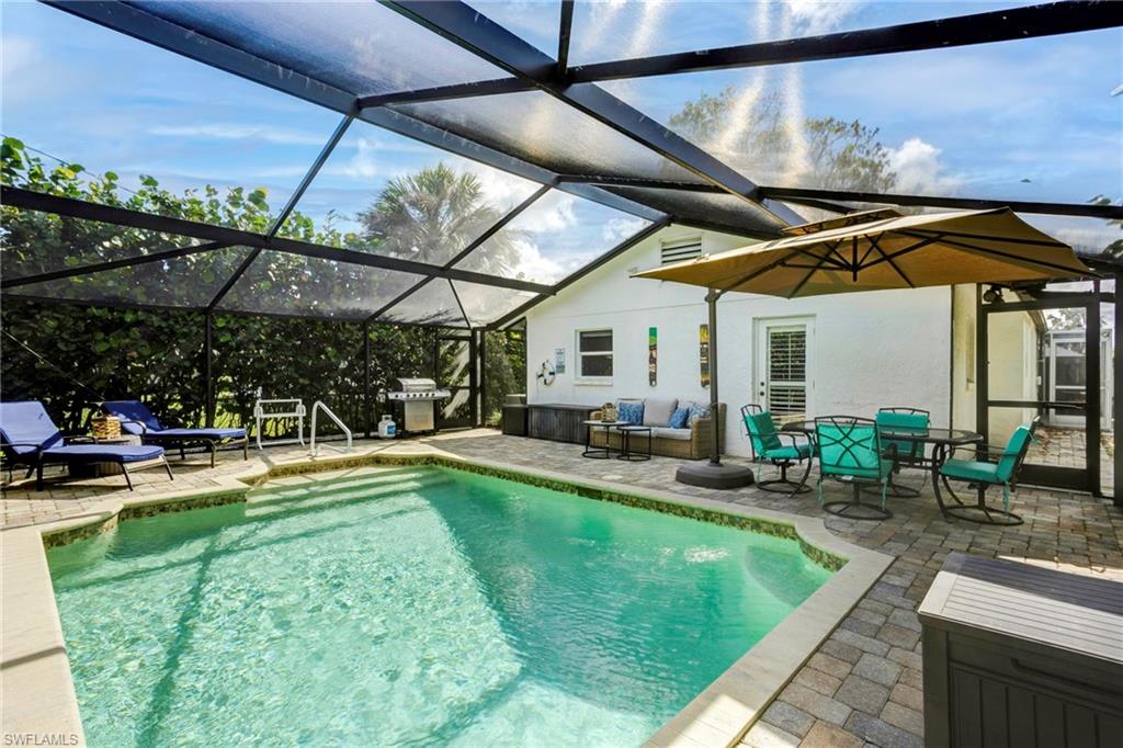 View of pool with a grill, a lanai, outdoor lounge area, and a patio area