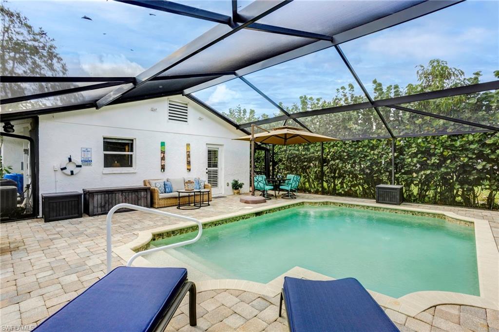 View of pool featuring an outdoor living space, a patio area, and glass enclosure