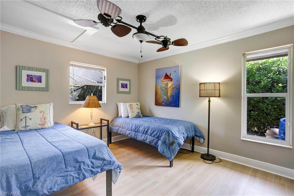 Bedroom featuring ornamental molding, a textured ceiling, and light wood-type flooring