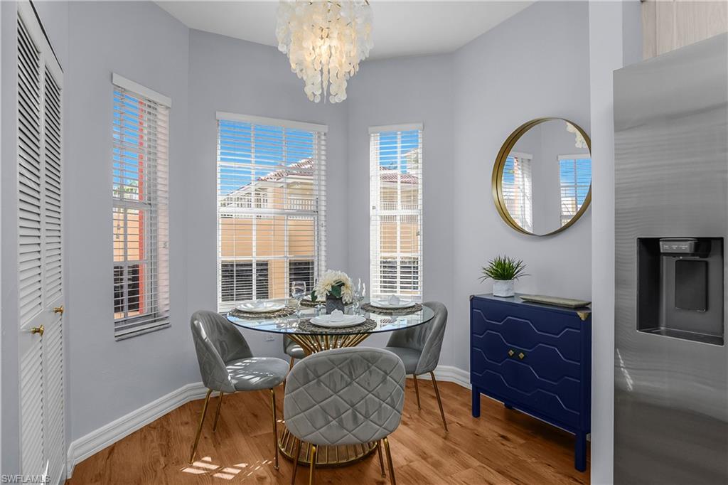 Dining space featuring a chandelier, wood finished floors, and healthy amount of natural light