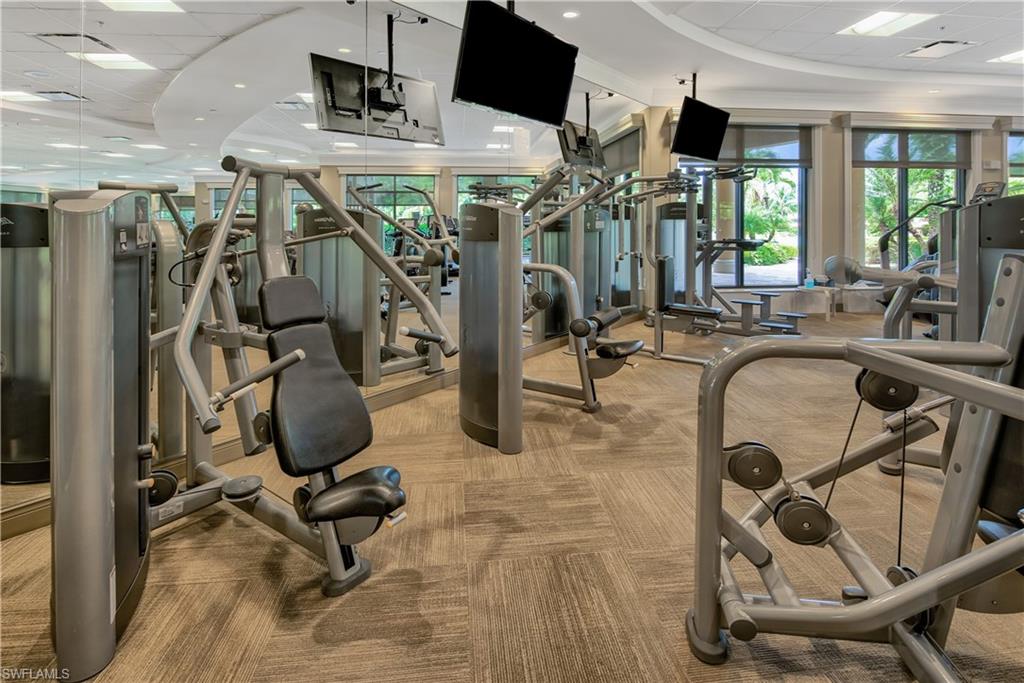 Exercise room with a drop ceiling and light carpet