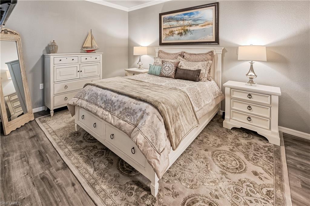 Bedroom featuring crown molding and dark wood-type flooring