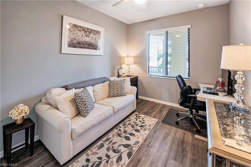 Home office with dark hardwood / wood-style floors and ceiling fan