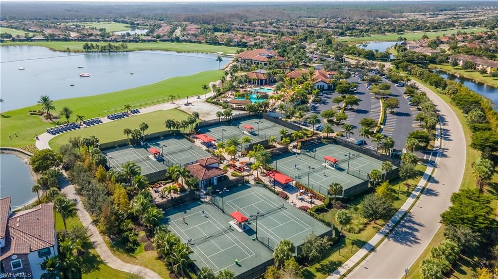 Aerial view of residential area featuring a nearby body of water and a local golf course