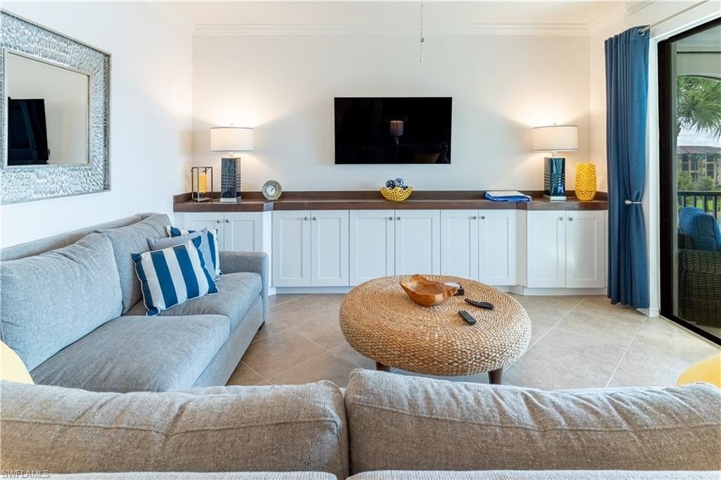 Living area featuring ornamental molding and light tile patterned flooring
