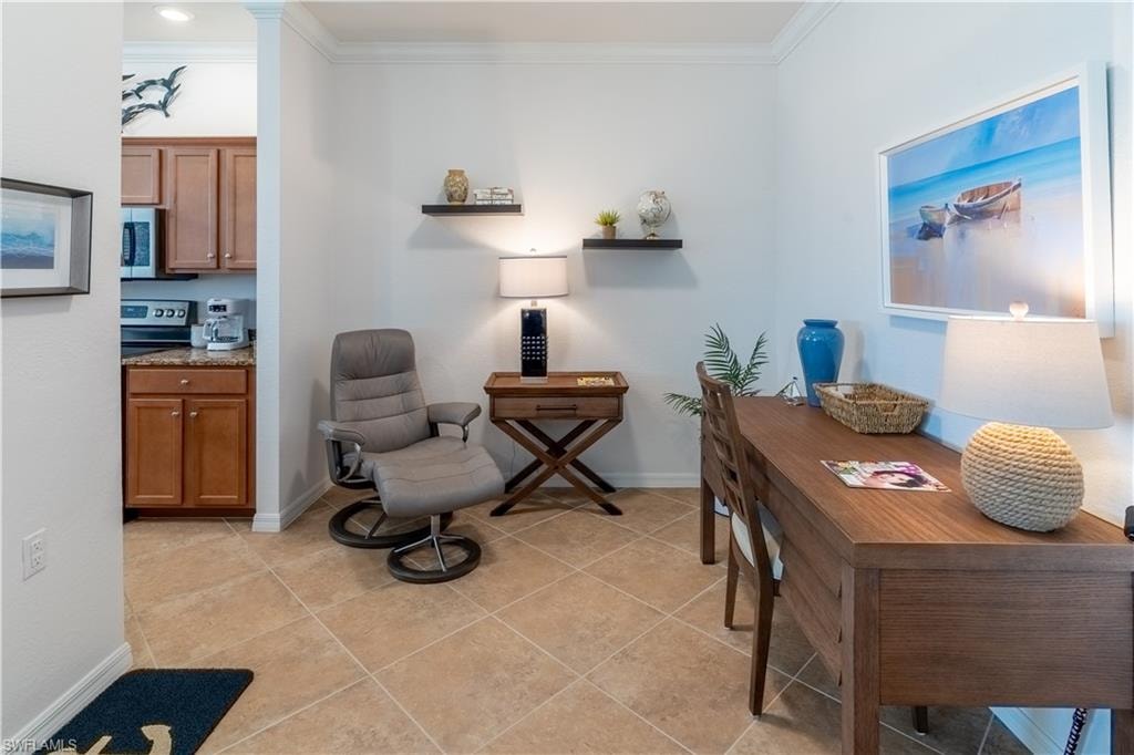 Living area with ornamental molding and light tile patterned floors