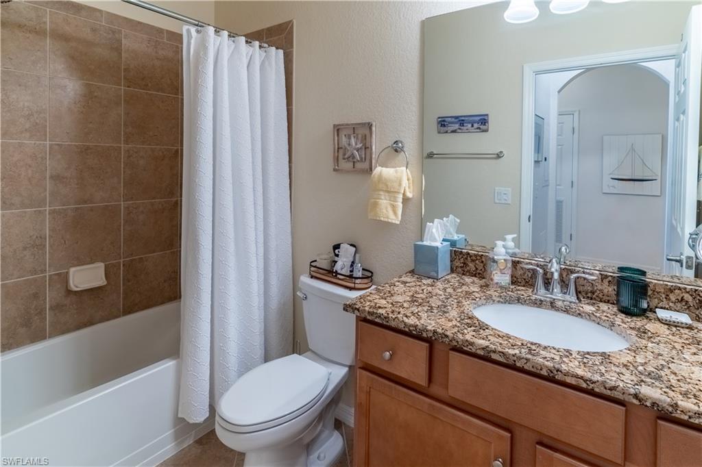 Bathroom with vanity, shower / tub combo, and a textured wall