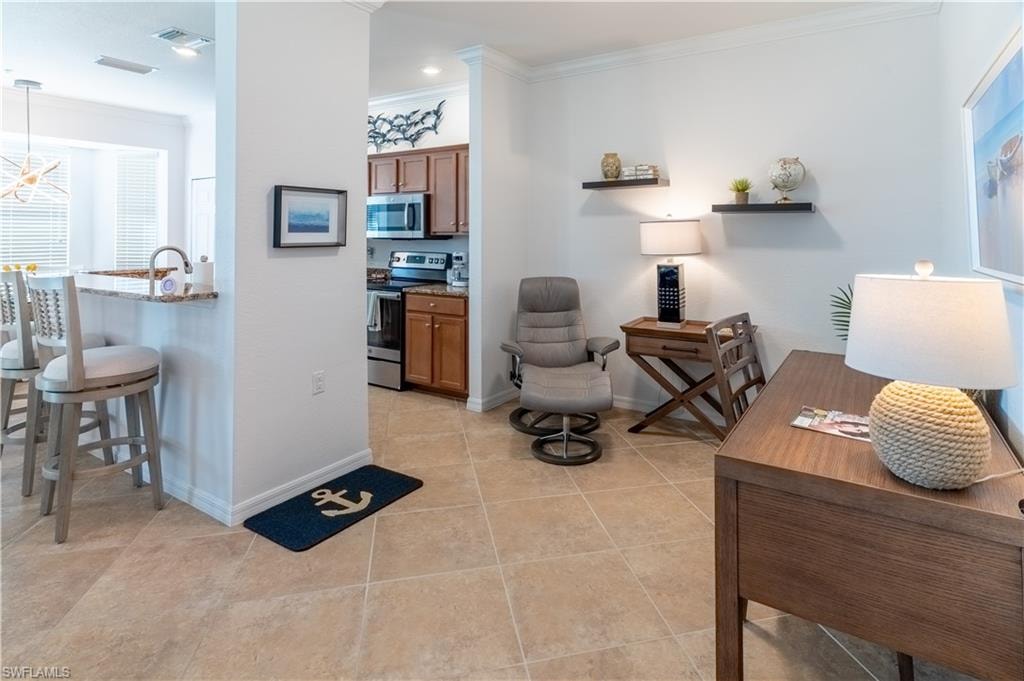 Living room featuring ornamental molding and light tile patterned floors