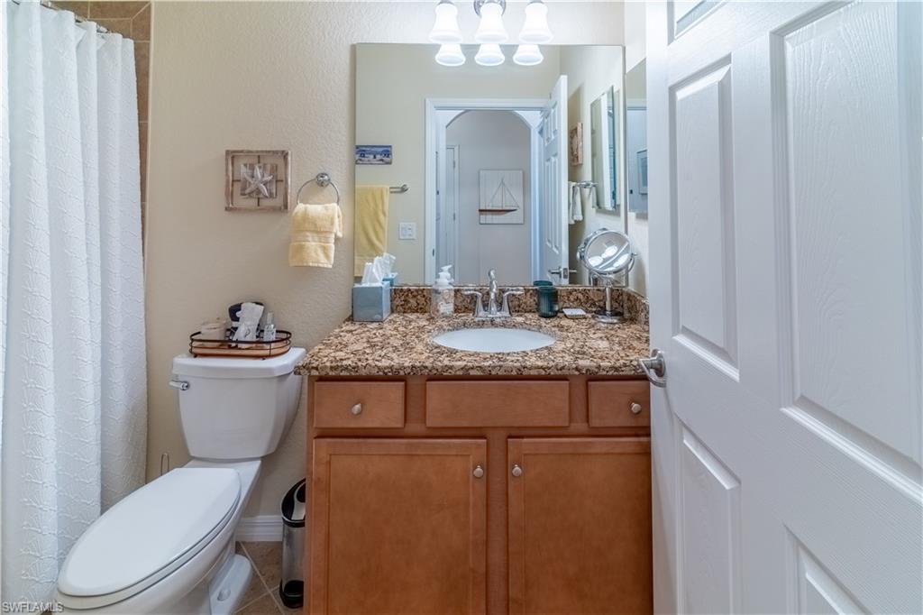 Full bathroom featuring vanity, a textured wall, and curtained shower
