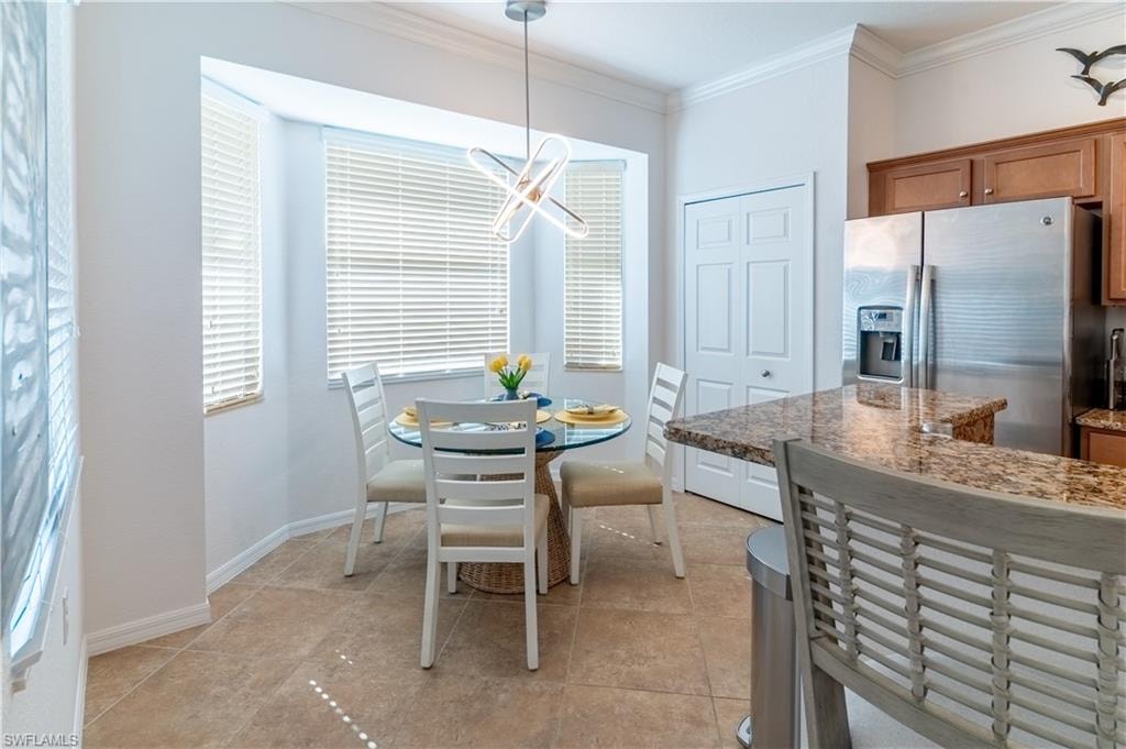 Dining area with ornamental molding and baseboards