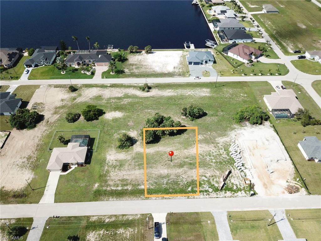 Aerial view of residential area featuring a large body of water and property parcel outlined
