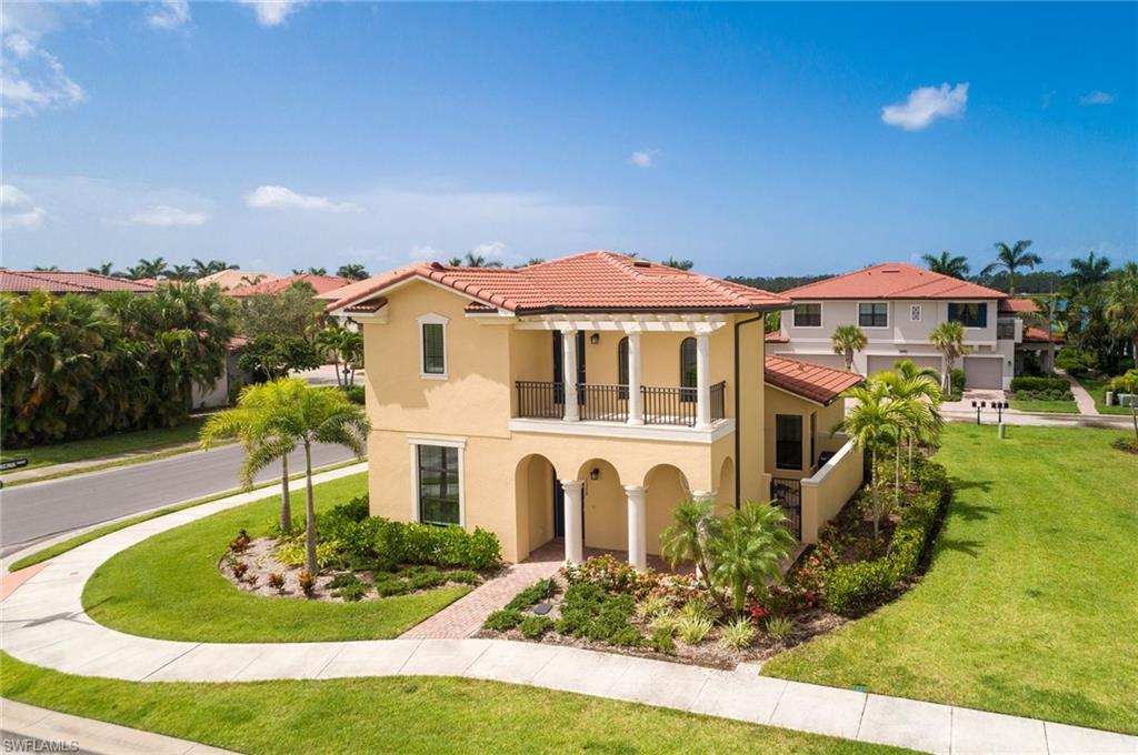 Mediterranean / spanish house featuring stucco siding, a front yard, a tiled roof, and a balcony