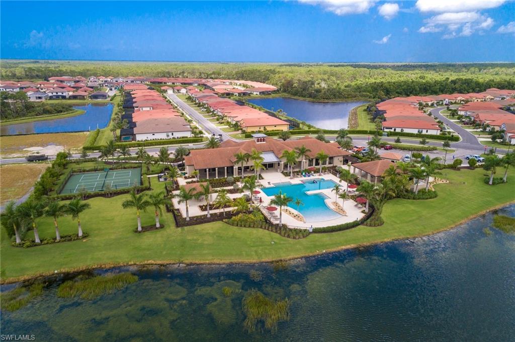 Aerial view of residential area with a nearby body of water and a pool