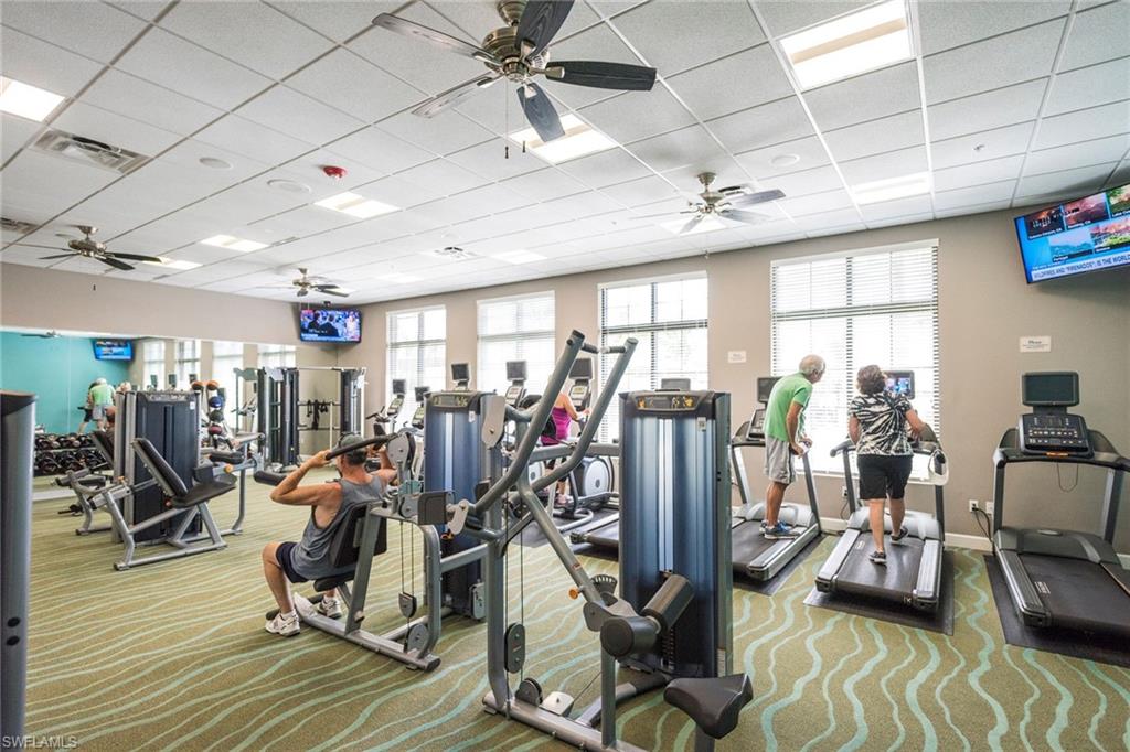 Exercise room featuring a ceiling fan and a drop ceiling