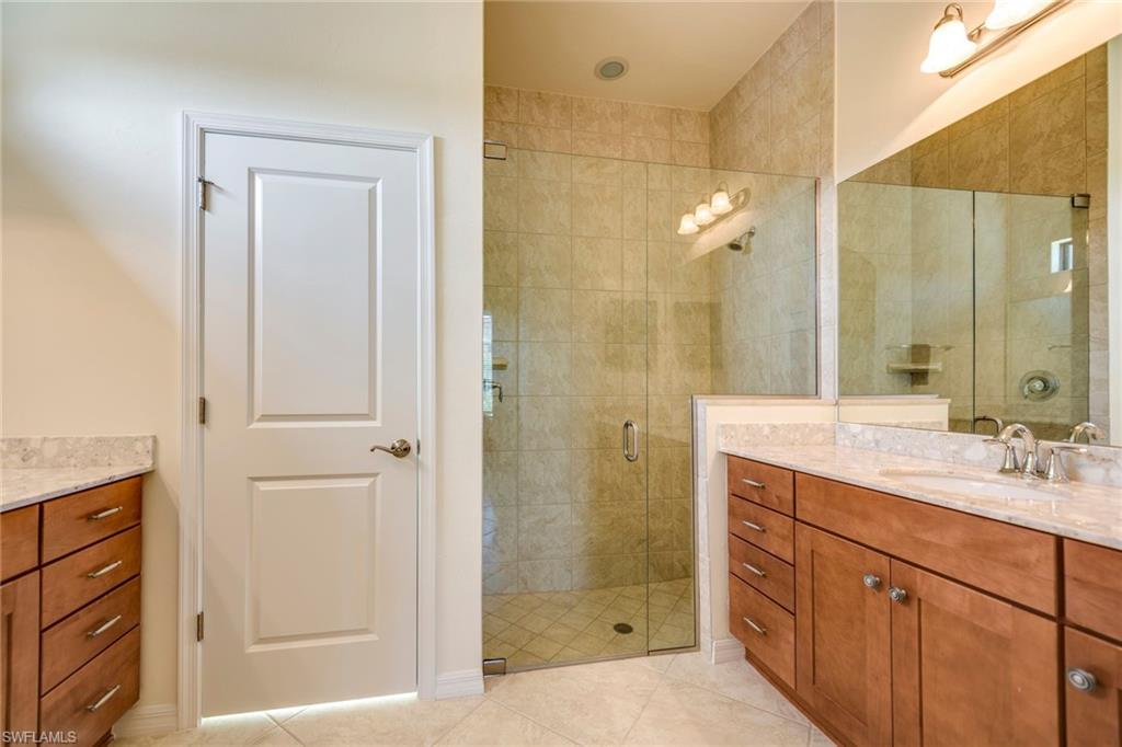 Bathroom featuring vanity, a stall shower, and light tile patterned floors