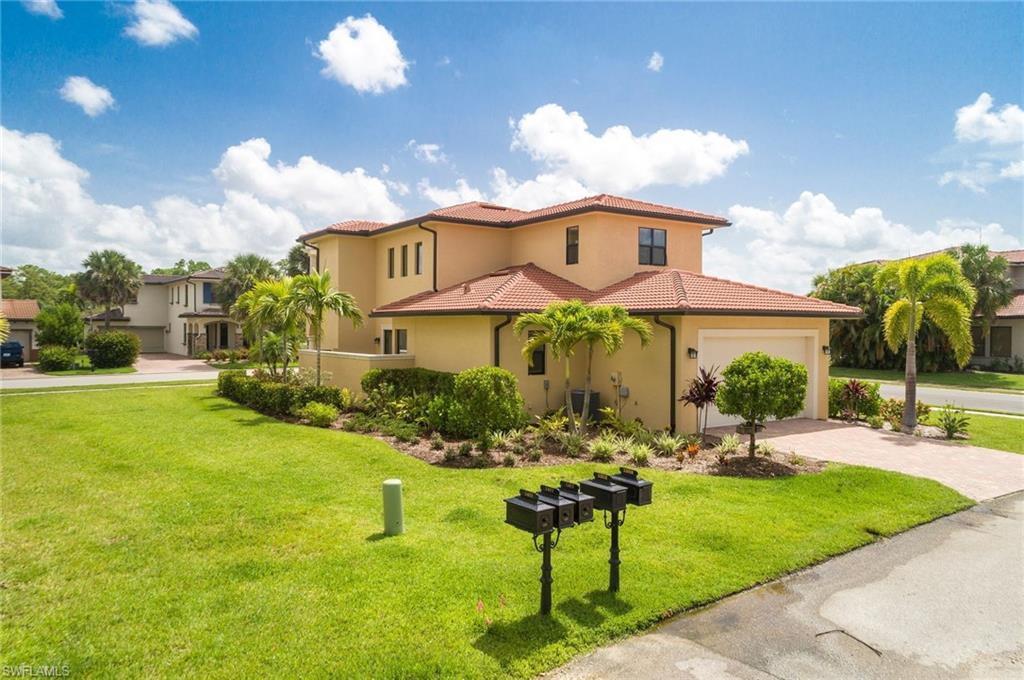 Mediterranean / spanish house featuring stucco siding, a front lawn, a tiled roof, decorative driveway, and a garage