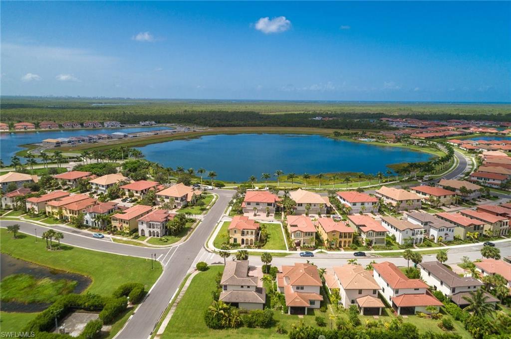 Aerial view of property and surrounding area featuring a nearby body of water and nearby suburban area