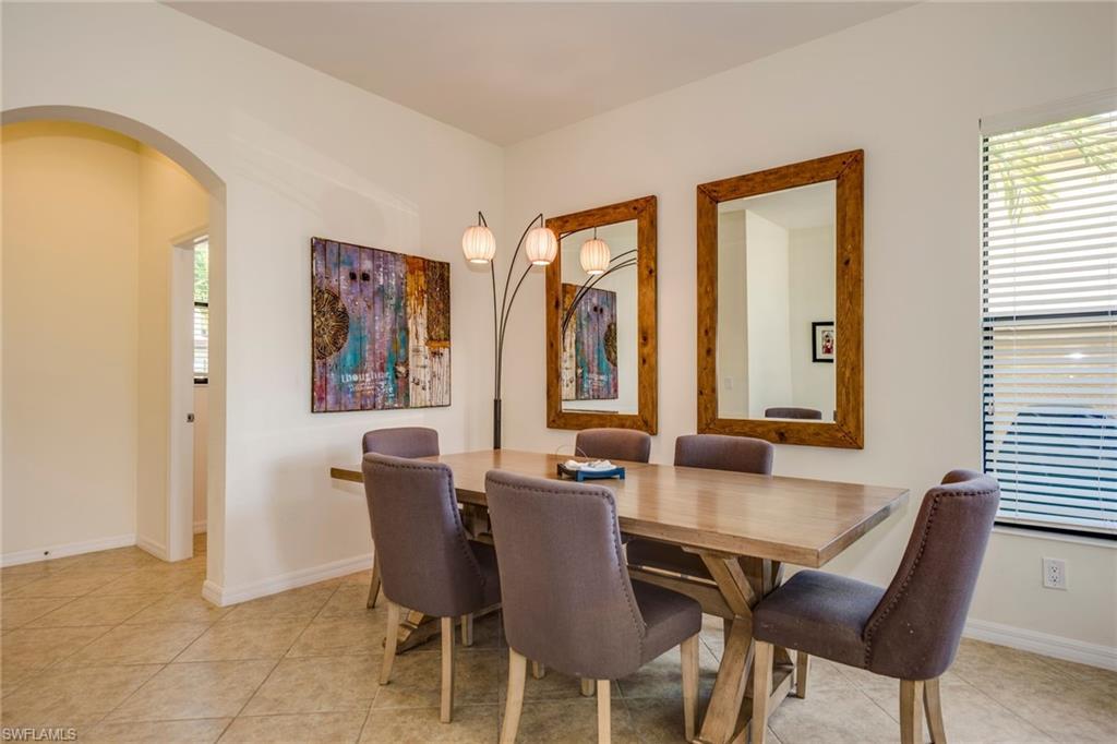 Dining space with arched walkways and light tile patterned flooring