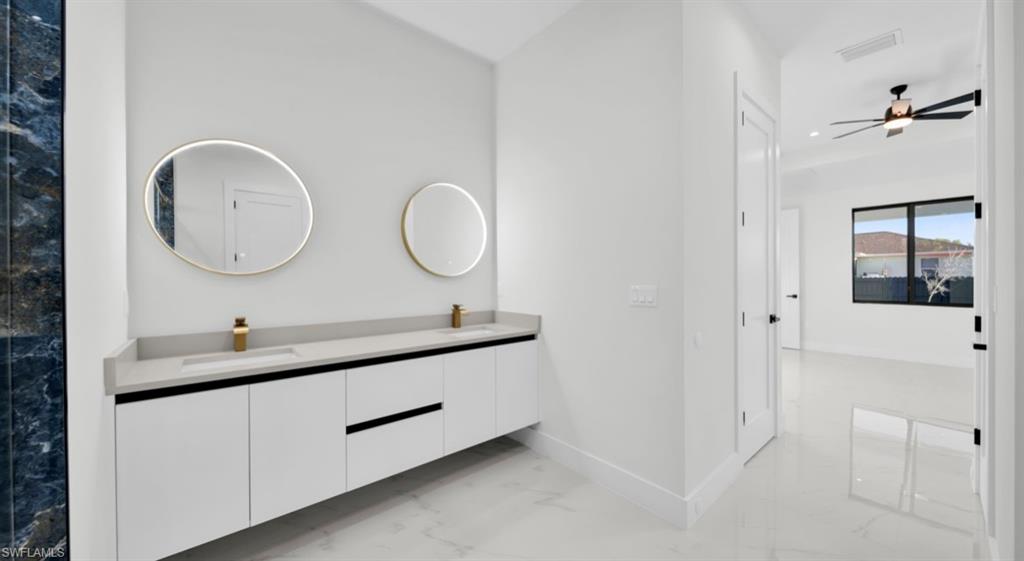 Bathroom featuring light marble finish floors, double vanity, a ceiling fan, and recessed lighting