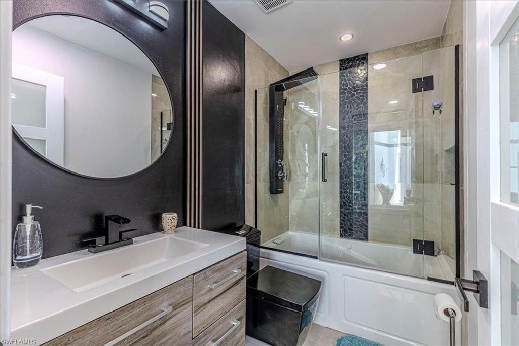 Full bathroom featuring bath / shower combo with glass door and vanity