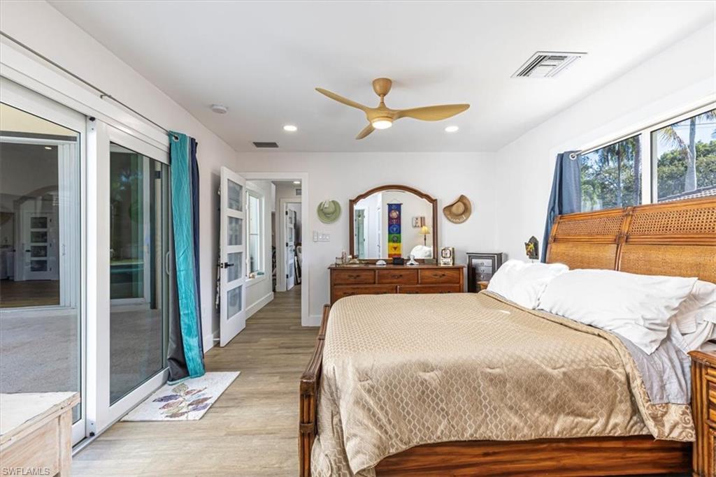 Bedroom featuring access to outside, light wood-style flooring, a ceiling fan, and recessed lighting