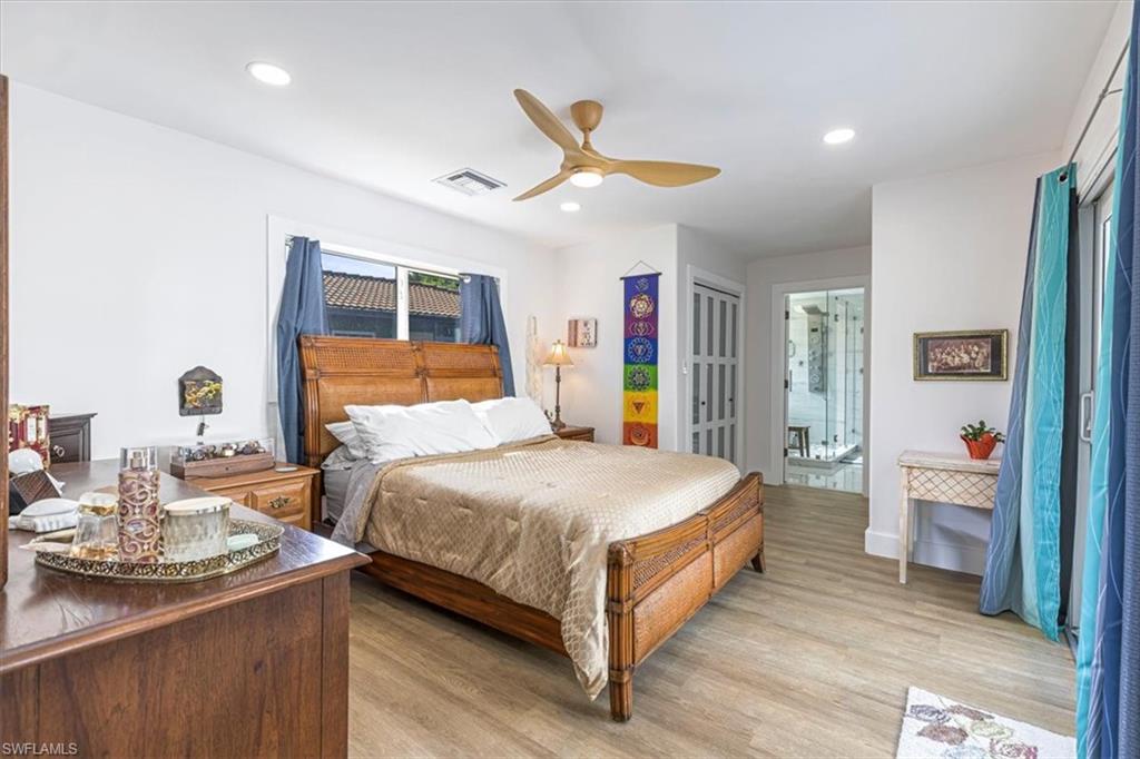 Bedroom with light wood-style flooring, ceiling fan, recessed lighting, and ensuite bathroom