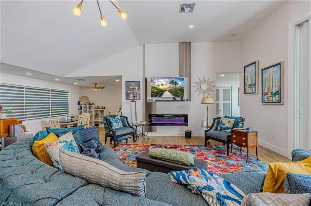 Living area featuring wood finished floors, recessed lighting, and high vaulted ceiling