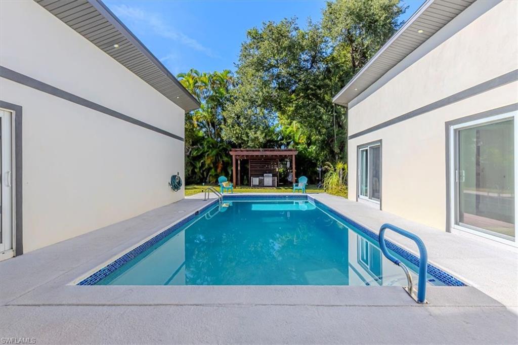 Swimming pool with a patio area and a pergola