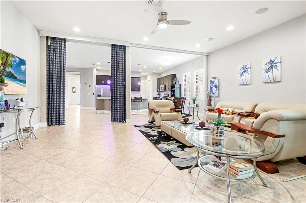 Living room featuring light tile patterned flooring, a ceiling fan, and recessed lighting