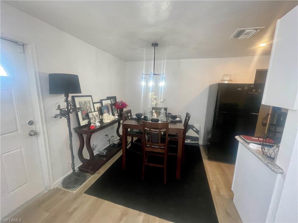 Dining area with light wood finished floors and a chandelier