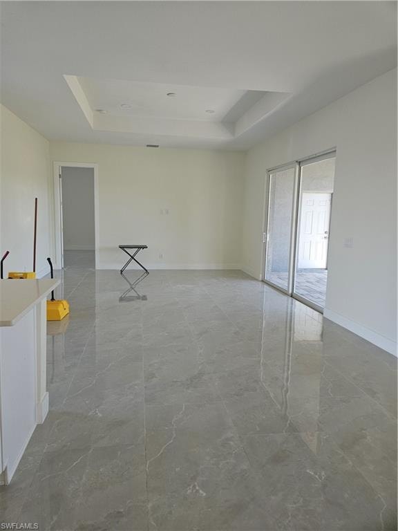 Empty room with a tray ceiling and light marble finish floors