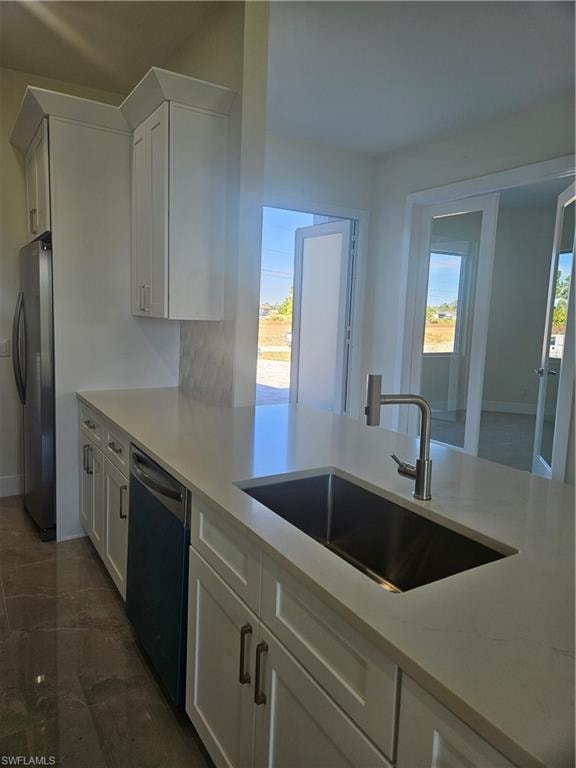 Kitchen with white cabinets, refrigerator, dishwashing machine, and decorative backsplash
