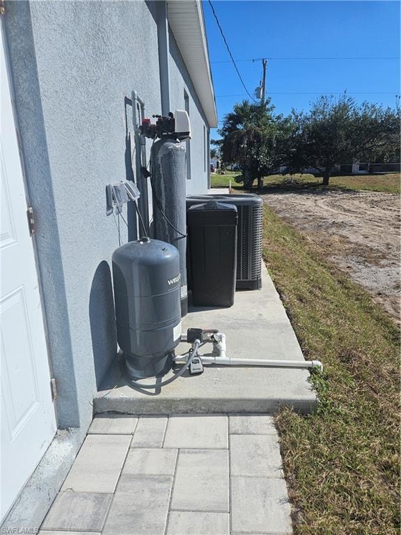 Exterior view of stucco siding and a water softener