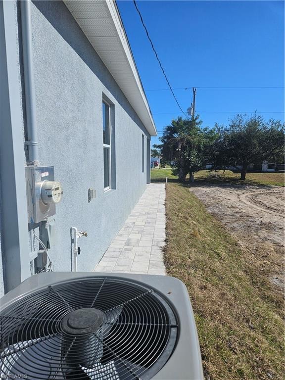 View of side of home featuring stucco siding and a lawn