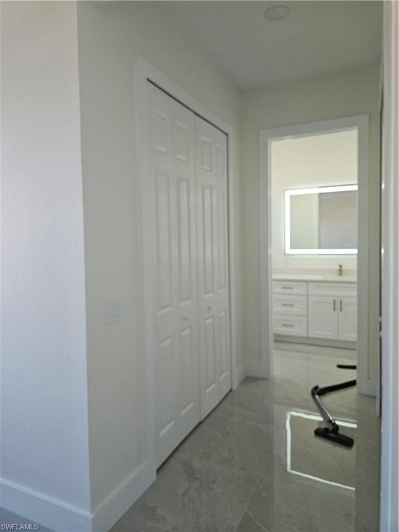 Hall with baseboards and light marble finish flooring