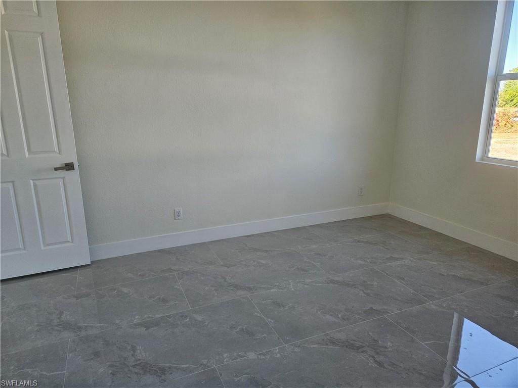Empty room featuring baseboards