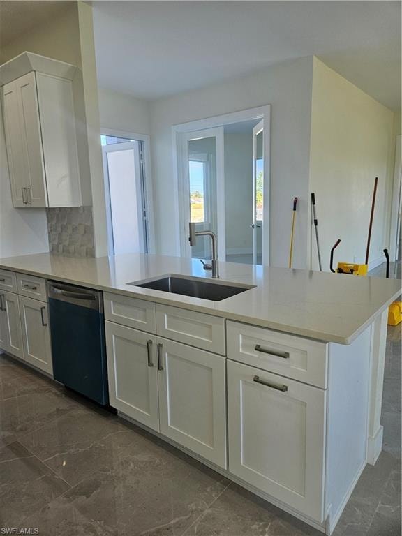 Kitchen featuring white cabinets, decorative backsplash, a peninsula, dishwasher, and light stone counters