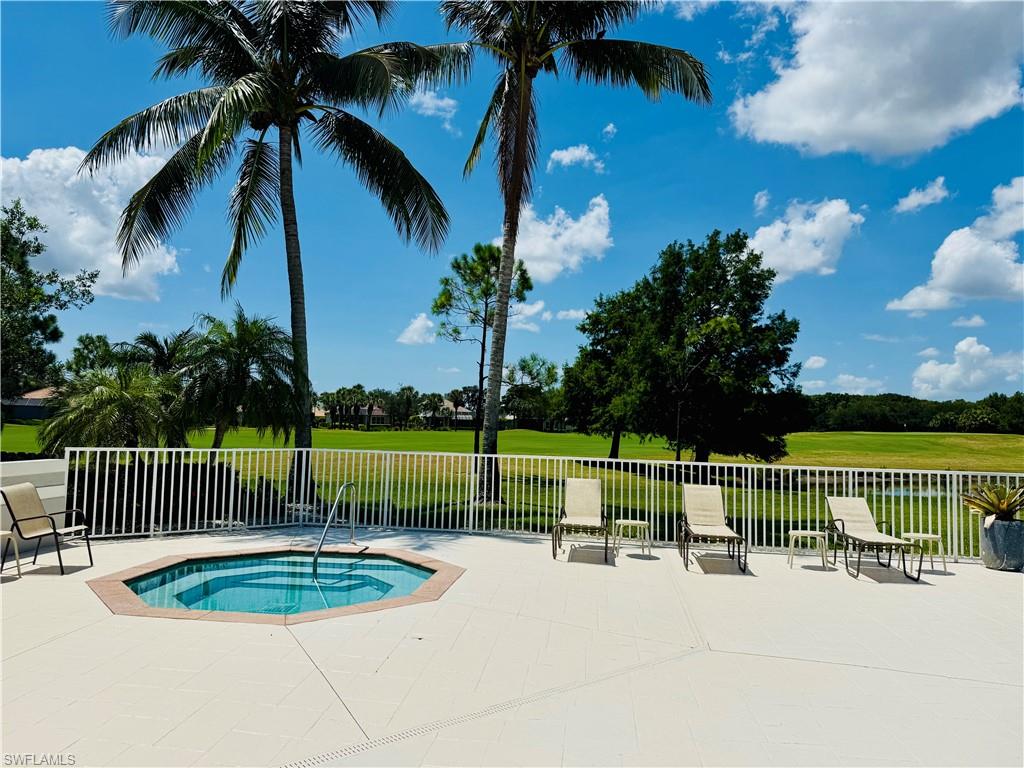 View of swimming pool featuring a patio area, an in-ground hot tub, and a lawn