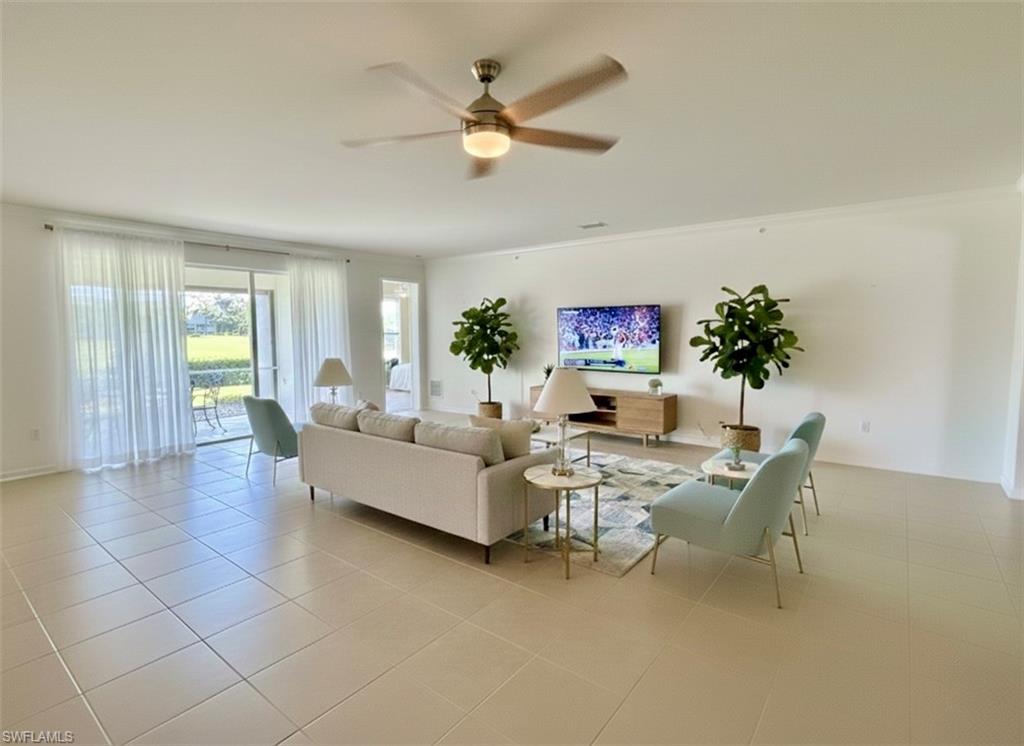 Living area with light tile patterned flooring, ceiling fan, and ornamental molding*Photos have been virtually staged for perspective.