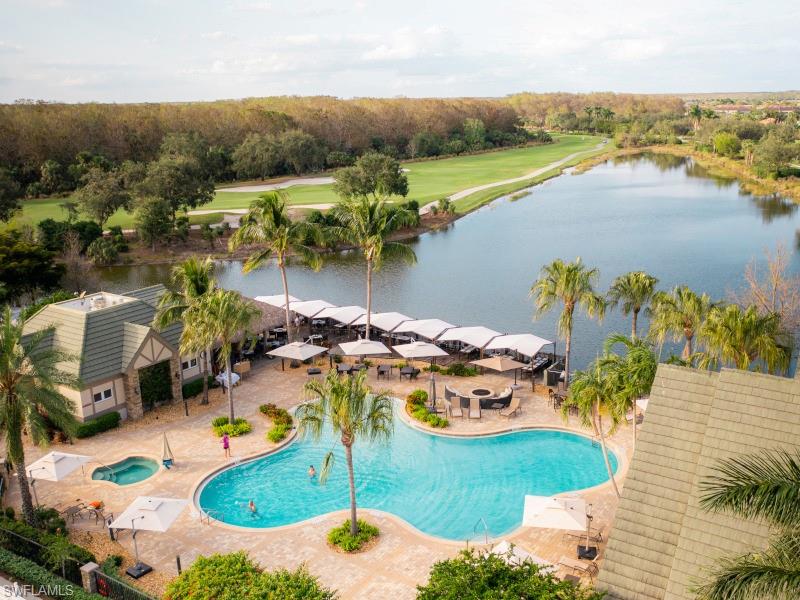 Community pool with a patio, a hot tub, and a water view