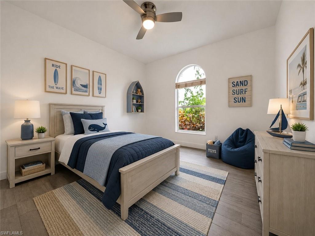 Bedroom featuring a vaulted ceiling with a flush-mount ceiling fan, wood-finish flooring, and an arched window